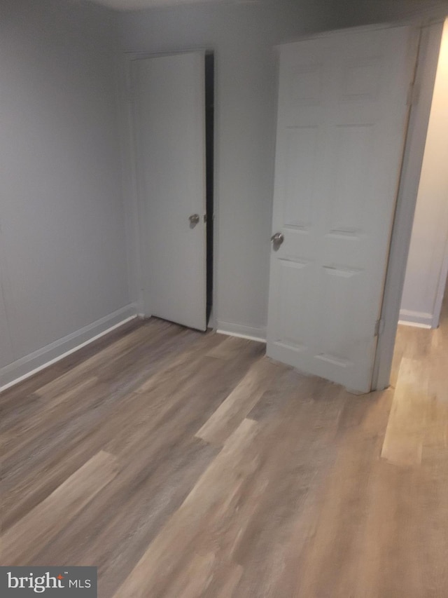 unfurnished bedroom with baseboards and wood finished floors