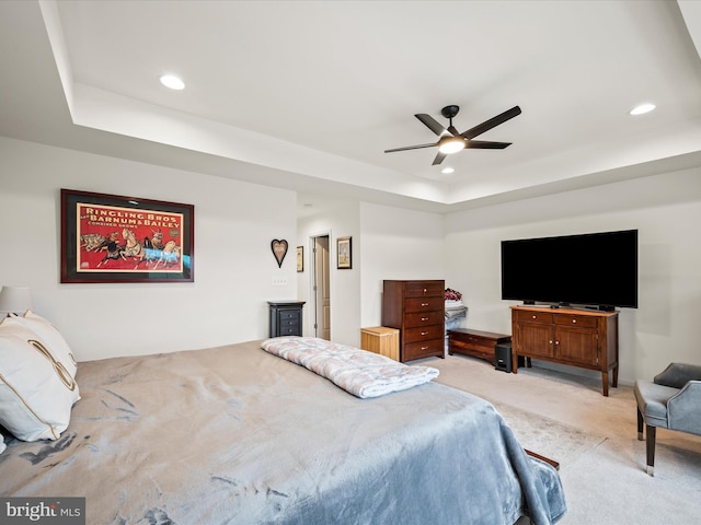 bedroom featuring light carpet, recessed lighting, a ceiling fan, and a tray ceiling