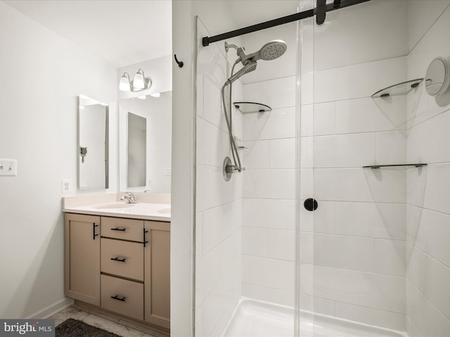 bathroom with double vanity, a stall shower, marble finish floor, and a sink