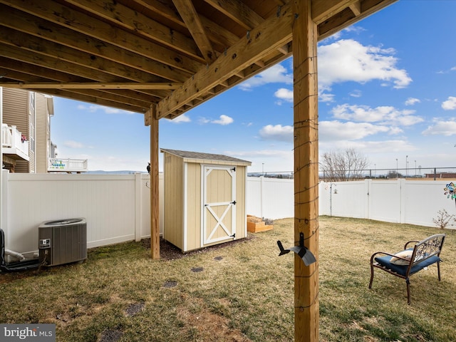 view of yard featuring an outbuilding, a shed, a fenced backyard, and central AC