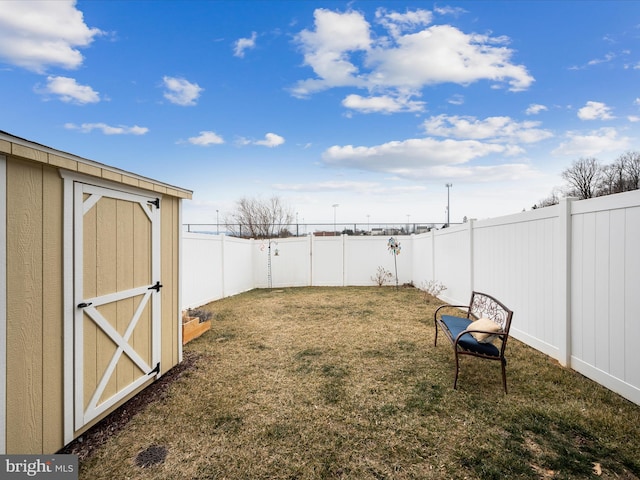 view of yard with an outbuilding, a shed, and a fenced backyard