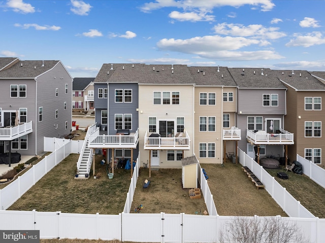 back of property featuring a residential view, a lawn, a fenced backyard, and a gate