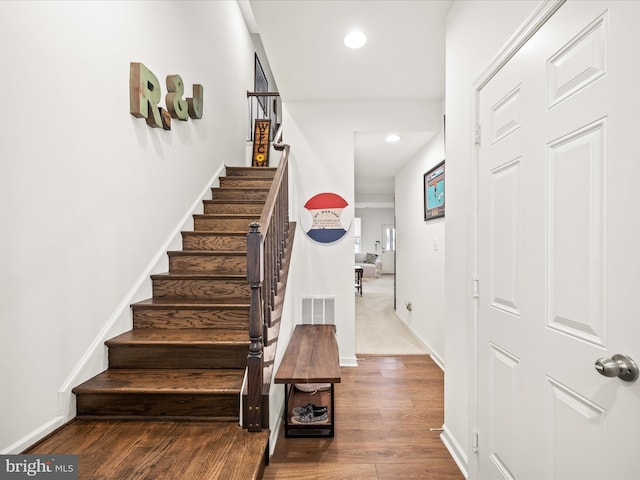 staircase featuring recessed lighting, wood finished floors, visible vents, and baseboards