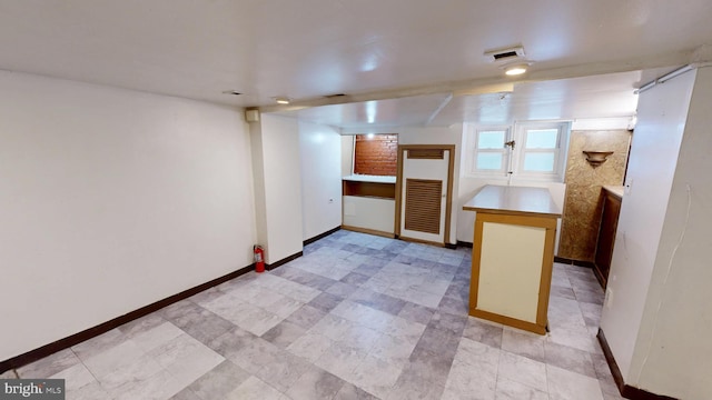 interior space with baseboards and light countertops