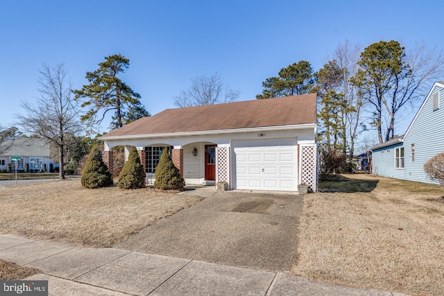 view of front facade featuring a garage, concrete driveway, a front lawn, and brick siding