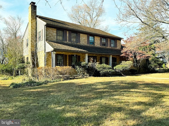 colonial home with a chimney and a front lawn