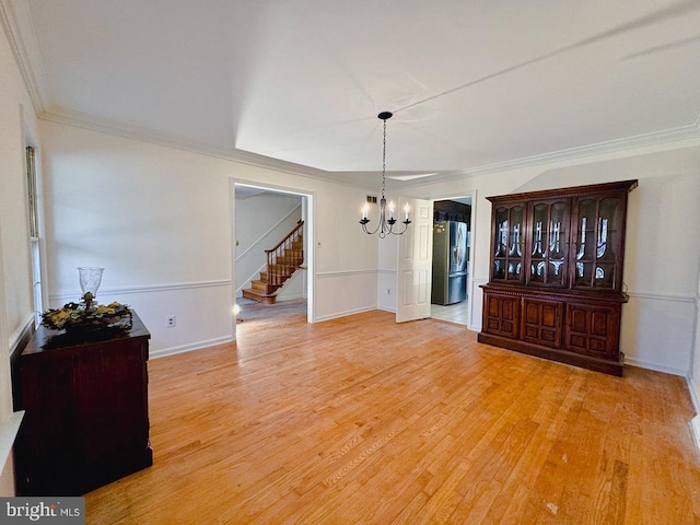 dining area with a notable chandelier, light wood finished floors, stairway, ornamental molding, and baseboards