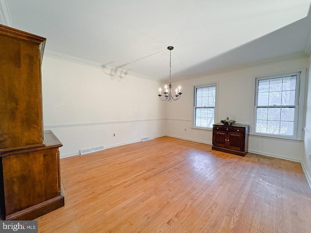 unfurnished dining area featuring crown molding, an inviting chandelier, visible vents, and light wood-style floors