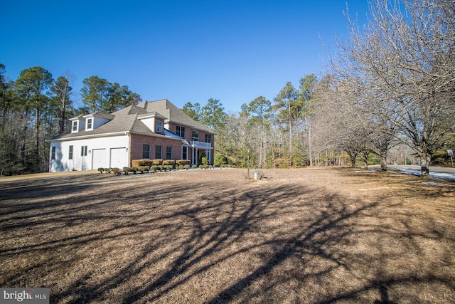 view of side of home featuring a garage and brick siding