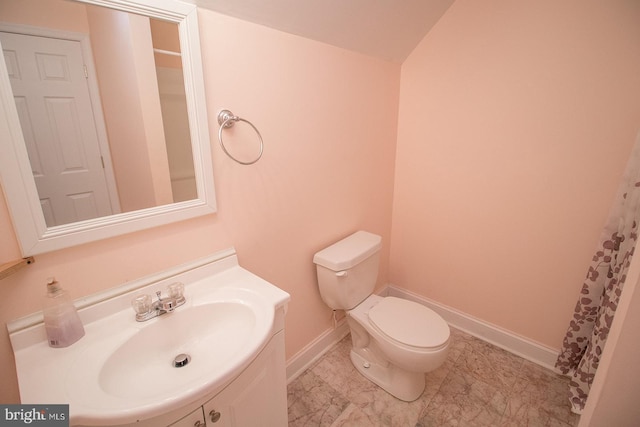 bathroom featuring baseboards, vanity, and toilet