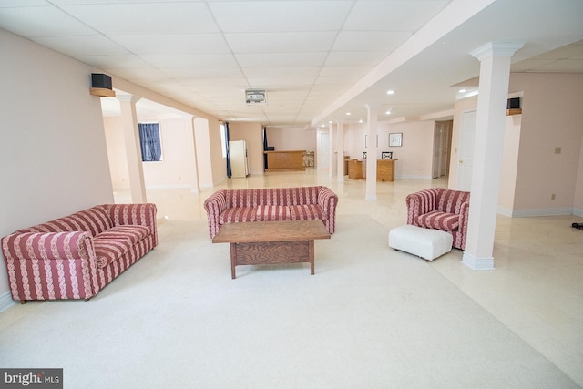 living area featuring a paneled ceiling, recessed lighting, decorative columns, and baseboards