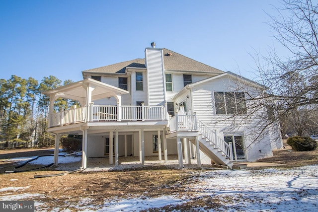 snow covered property featuring a deck and a chimney