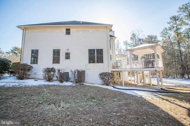 snow covered house featuring a deck and cooling unit