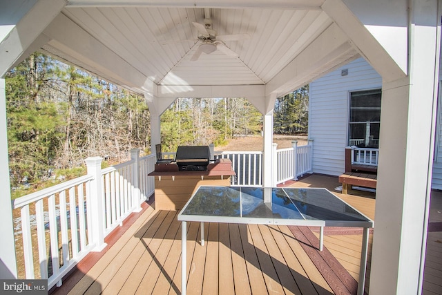 wooden deck featuring ceiling fan and area for grilling