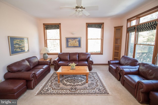 living area featuring ceiling fan, ornamental molding, baseboards, and light colored carpet