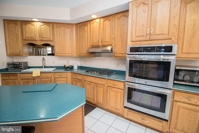 kitchen with a toaster, light tile patterned floors, appliances with stainless steel finishes, a sink, and under cabinet range hood