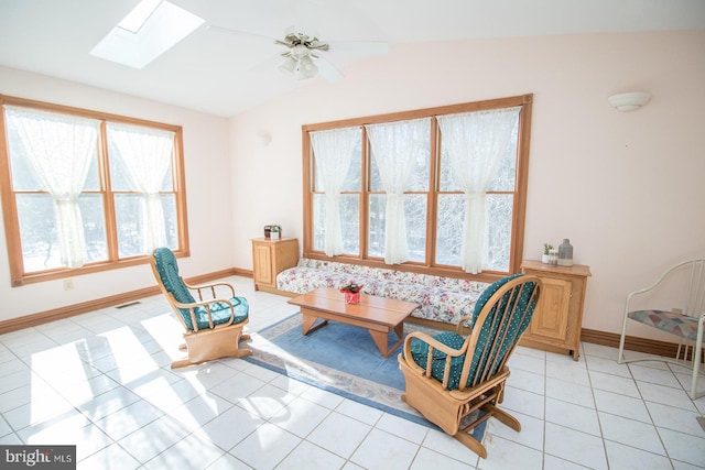 living area with vaulted ceiling with skylight, visible vents, baseboards, a ceiling fan, and light tile patterned flooring