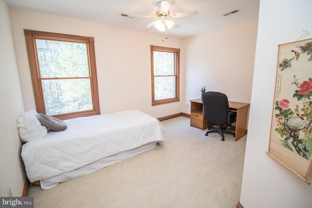 bedroom featuring light carpet, baseboards, visible vents, and a ceiling fan