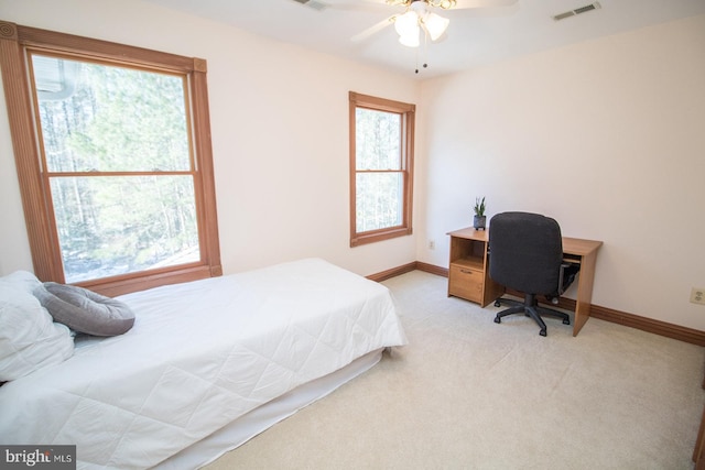 bedroom featuring light colored carpet, visible vents, and multiple windows