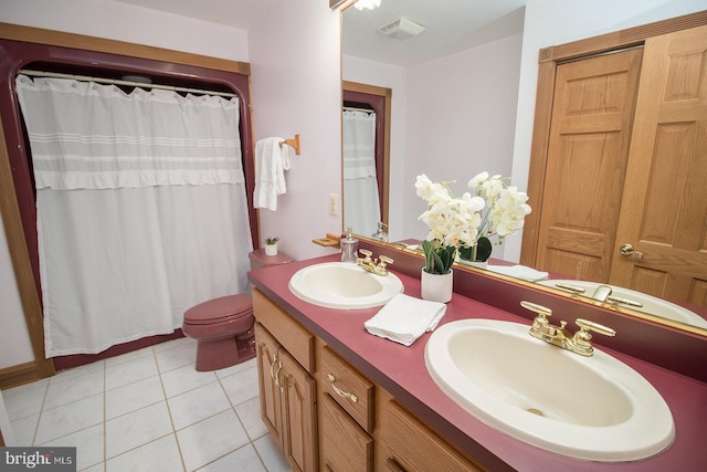 bathroom with double vanity, visible vents, a sink, and tile patterned floors