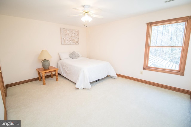 carpeted bedroom with visible vents, ceiling fan, and baseboards