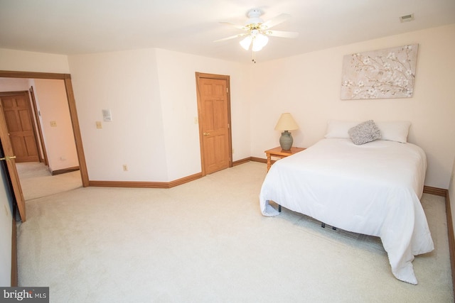 carpeted bedroom with visible vents, baseboards, and a ceiling fan