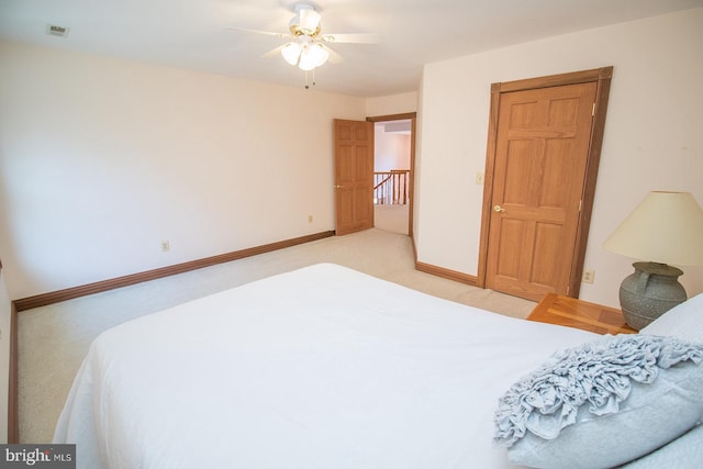 bedroom featuring ceiling fan, light colored carpet, visible vents, and baseboards