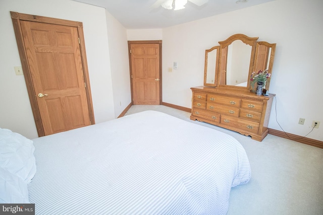 bedroom featuring a ceiling fan, light carpet, and baseboards