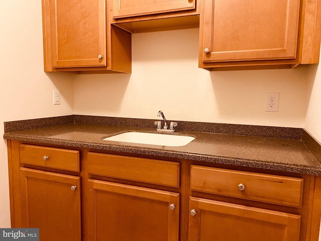 kitchen with dark countertops and a sink