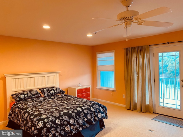 bedroom featuring access to exterior, multiple windows, light carpet, and baseboards