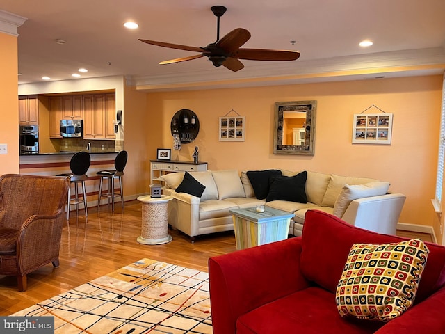 living area with ceiling fan, light wood finished floors, baseboards, and recessed lighting