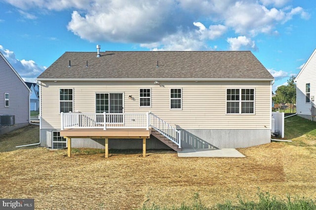 rear view of property featuring stairs, central AC, a lawn, and a wooden deck