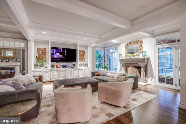 living room with crown molding, beamed ceiling, a fireplace, and light wood-style floors