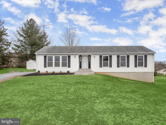 view of front of house with a shingled roof, an outbuilding, gravel driveway, a storage unit, and a front yard