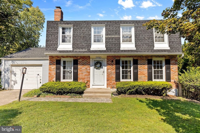 view of front of home with an attached garage, brick siding, a front lawn, and roof with shingles