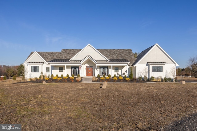 ranch-style house featuring a standing seam roof, covered porch, and metal roof