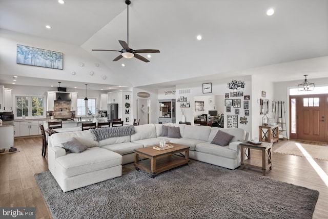 living room with ceiling fan, high vaulted ceiling, recessed lighting, visible vents, and light wood-style floors