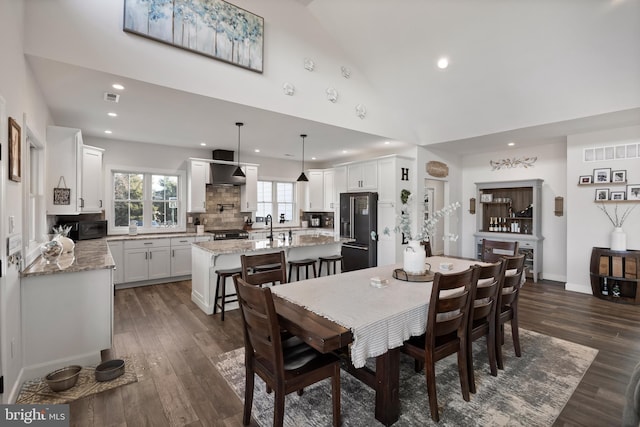 dining area with visible vents, vaulted ceiling, dark wood-type flooring, and recessed lighting