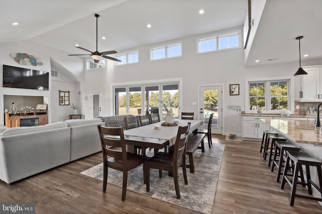 dining space featuring ceiling fan, high vaulted ceiling, dark wood finished floors, and recessed lighting