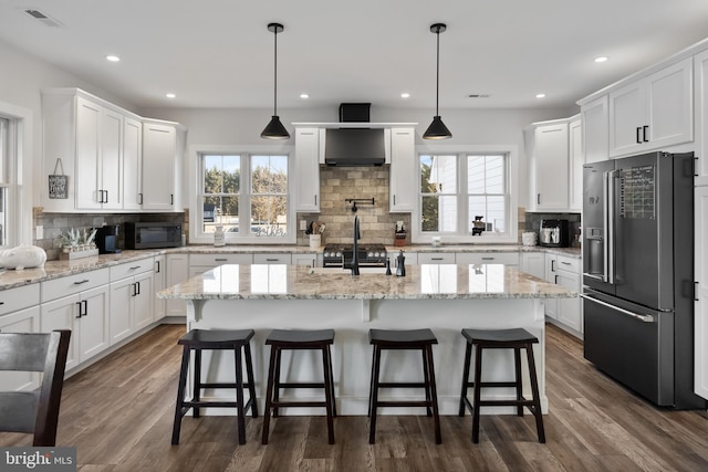 kitchen featuring plenty of natural light, visible vents, white cabinets, and premium appliances