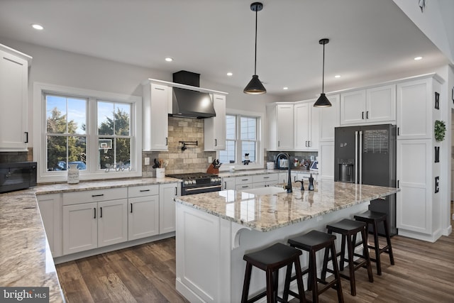 kitchen with a sink, white cabinetry, wall chimney exhaust hood, dark wood-style floors, and black appliances