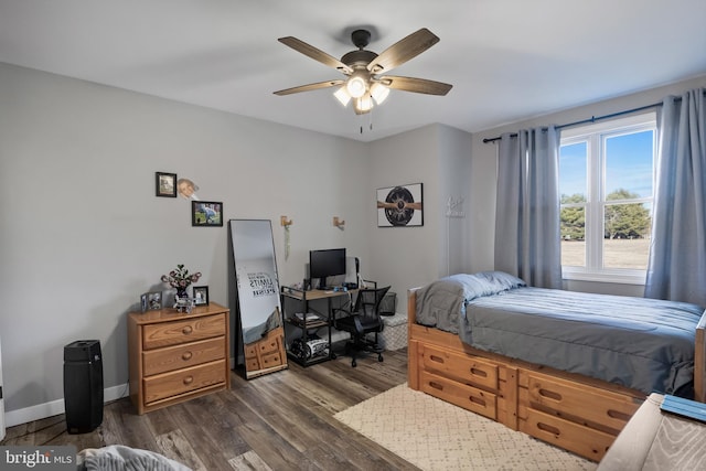 bedroom with ceiling fan, dark wood-type flooring, and baseboards