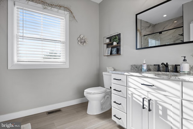 full bath featuring a marble finish shower, baseboards, visible vents, toilet, and vanity