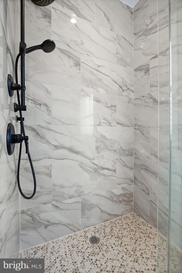 bathroom featuring a marble finish shower