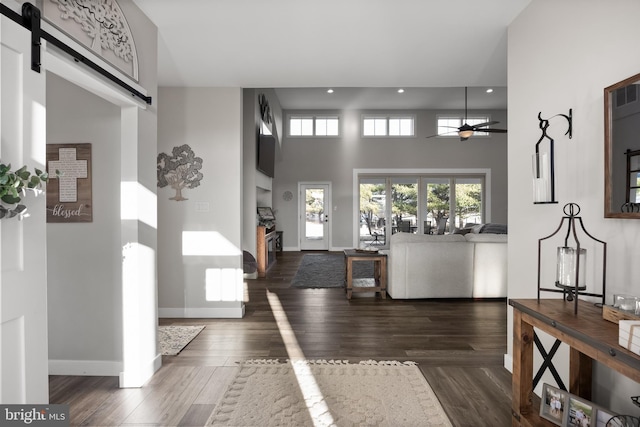 entryway featuring wood finished floors, baseboards, and a barn door