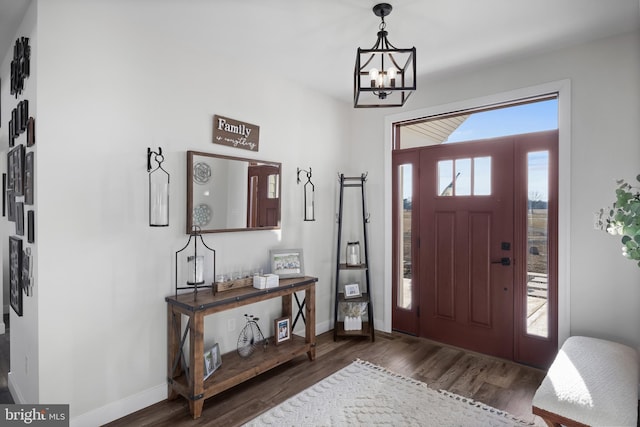 entryway with an inviting chandelier, baseboards, and wood finished floors