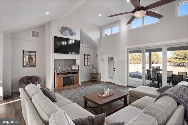 living area featuring high vaulted ceiling, visible vents, and dark wood finished floors