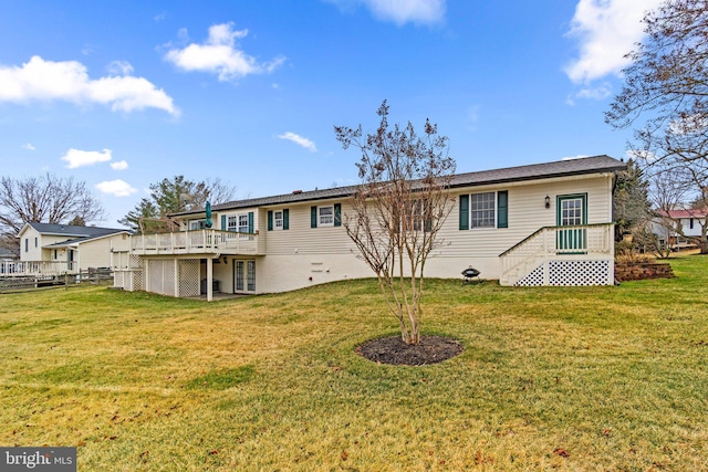 rear view of property with a deck and a yard