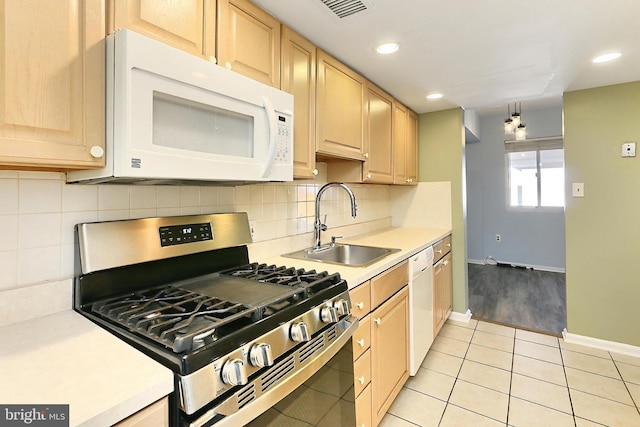 kitchen featuring a sink, white appliances, light brown cabinetry, and light countertops