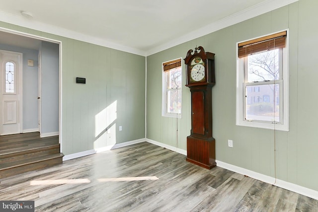 foyer entrance with plenty of natural light, crown molding, and wood finished floors